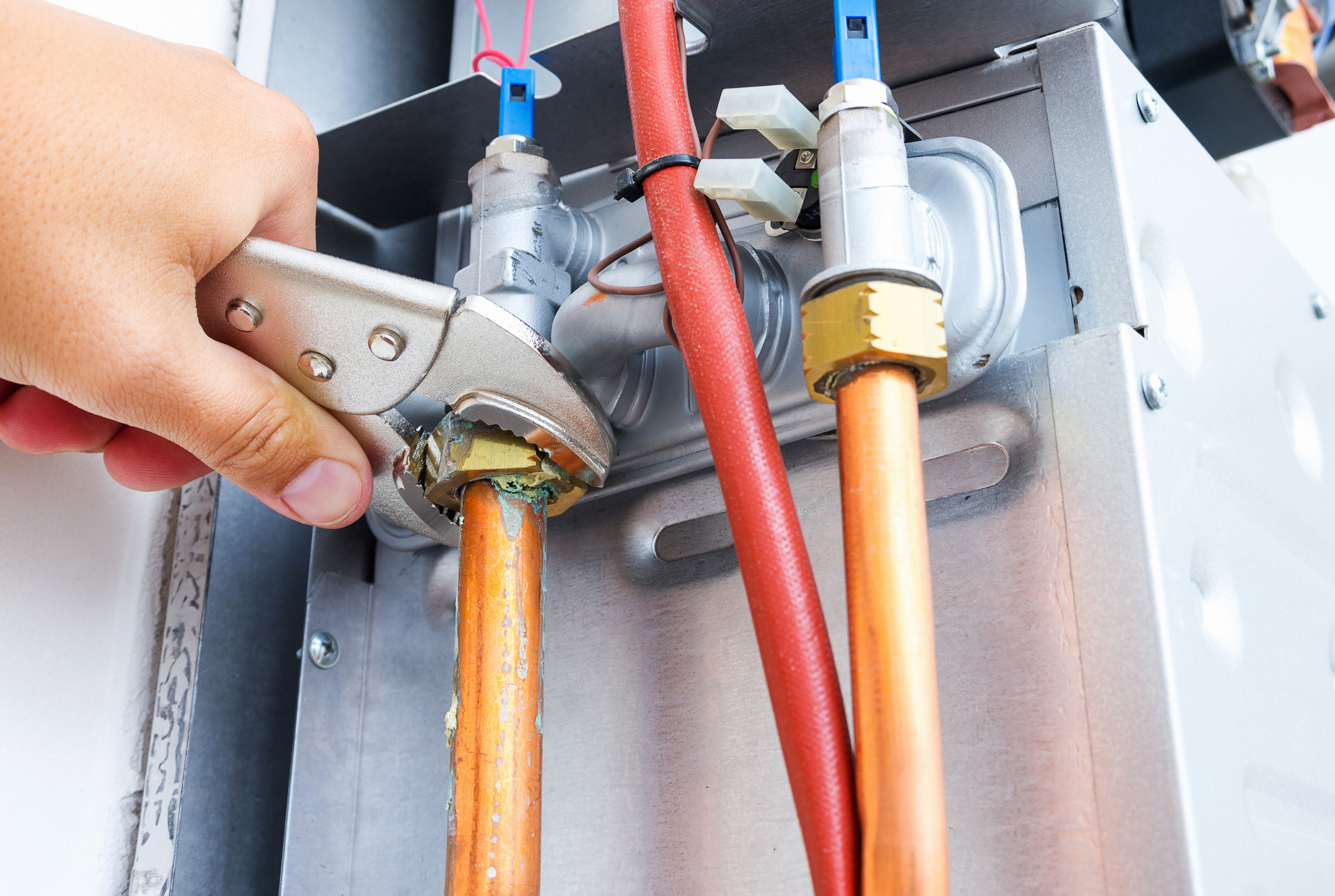 Plumber repairing a gas boiler of a heating home system in the boiler room